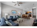 A cozy living room with a sofa, ceiling fan, and views of the dining area and kitchen at 4551 Jonafree Ln # 103, Kissimmee, FL 34746