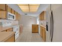 Open kitchen flowing into a dining area with white appliances and light wood cabinets at 572 Floral Dr, Kissimmee, FL 34743