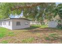 Lush backyard featuring mature trees and a convenient storage shed at 673 E Church Ave, Longwood, FL 32750
