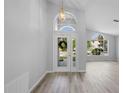 Bright foyer featuring wood flooring, a decorative front door, and an arched window above the doorway at 707 Stonewyk Way, Kissimmee, FL 34744