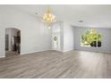 Open living area with vaulted ceilings, wood flooring, and an elegant chandelier at 707 Stonewyk Way, Kissimmee, FL 34744