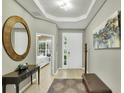 Elegant home entryway with light wood floors, bench, decor, and a view to the front door at 7745 Comrow St, Kissimmee, FL 34747