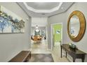 Inviting home entryway with modern decor, light wood floors, an elegant foyer, and views to the living area at 7745 Comrow St, Kissimmee, FL 34747