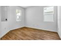 Bright bedroom with wood-look tile flooring and two windows for natural light at 815 Lake Dell Rd, Dundee, FL 33838