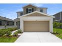 Exterior view of a two-story home featuring a 2 car garage and manicured landscaping at 815 Lake Dell Rd, Dundee, FL 33838