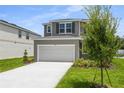 Inviting two-story home featuring a spacious two car garage and manicured front lawn at 819 Lake Dell Rd, Dundee, FL 33838