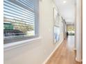 Bright hallway featuring wood floors, neutral colored walls and large windows with blinds at 819 Lake Dell Rd, Dundee, FL 33838