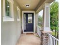 View of front porch with stone pillar accents, decorative wreath on front door, and black hardware at 8635 Tallfield Ave, Orlando, FL 32832