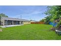 Spacious backyard featuring a screened-in patio and lush green lawn at 1013 Carefree Cove Dr, Winter Haven, FL 33881
