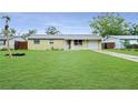 Home exterior featuring a neatly kept lawn and attached garage on a sunny day at 1013 Carefree Cove Dr, Winter Haven, FL 33881
