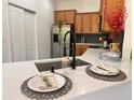 Well-equipped kitchen with quartz countertops, black faucet, and stainless steel refrigerator at 10734 Dawson Lily Way # S, Orlando, FL 32832