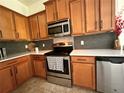 Modern kitchen featuring stainless steel appliances, stylish cabinets, and a gray backsplash at 10734 Dawson Lily Way # S, Orlando, FL 32832