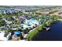 Aerial view of community pool and clubhouse with a playground, splashpad, and waterfront park with pier at 1614 Lima Ave, Kissimmee, FL 34747