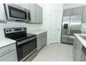 Modern kitchen with stainless steel appliances, grey cabinets, and light countertops at 165 Citrine Loop, Kissimmee, FL 34758