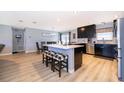 Modern eat-in kitchen with dark cabinetry, stainless steel appliances, an island, and stylish bar stools at 1730 Carolyn Ct, St Cloud, FL 34769