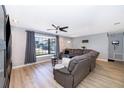 Comfortable living room with wood floors, gray walls, a large sectional sofa, and lots of natural light at 1730 Carolyn Ct, St Cloud, FL 34769