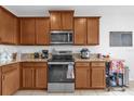 Well-equipped kitchen with stainless steel appliances, ample wooden cabinetry, and granite countertops at 2060 Patriot Way, St Cloud, FL 34769
