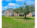 Single-story home with a well-manicured lawn and mature trees for shade at 215 Grovepark Dr, Davenport, FL 33837