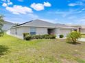 Lovely single-story home with lush green lawn, complemented by garden with shrubs and plants at 233 E Cattail, Lake Alfred, FL 33850