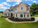 Charming two-story home with stone accents, manicured landscaping, and a brick walkway leading to the front entrance at 2350 Bradbury Rd, Haines City, FL 33844