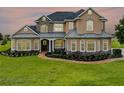 Elegant two-story home displaying lush landscaping, stone accents and a winding walkway to the covered front porch at 2350 Bradbury Rd, Haines City, FL 33844
