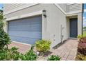 Close-up showcasing the entrance of a townhome, featuring a blue-gray door and brick walkway at 2462 Sweet Viburnum Way, Ocoee, FL 34761