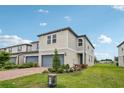 Beautiful townhome featuring manicured landscaping, a brick driveway, and an attached garage at 2462 Sweet Viburnum Way, Ocoee, FL 34761