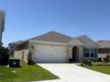 Single-story home with a neutral color scheme, well-maintained lawn, and an attached garage at 2569 Trinidad Rd, Haines City, FL 33844
