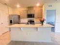 Modern kitchen features stainless steel appliances, a central island, and sleek countertops at 2569 Trinidad Rd, Haines City, FL 33844