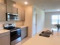 Kitchen featuring gray cabinetry, stainless appliances, and a quartz-topped island at 2569 Trinidad Rd, Haines City, FL 33844