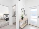 Bright entryway featuring a modern console table, stylish mirror, and views into the bedroom at 2605 Scrapbook St, Kissimmee, FL 34746
