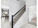 Elegant staircase with dark wood railing and carpeted steps in a bright, modern home at 2605 Scrapbook St, Kissimmee, FL 34746