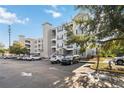 Three-story condo building featuring balconies, neutral siding and a well-maintained parking area on a clear day at 3175 Feltrim Pl # 101, Kissimmee, FL 34747