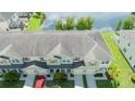 An elevated view of townhouses near a pond, showcasing the roofs, garages, and surrounding greenery at 3181 Tocoa Cir, Kissimmee, FL 34746