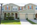 Inviting townhouse exterior with a two-car garage and well-maintained landscaping and beautiful shutters at 3181 Tocoa Cir, Kissimmee, FL 34746