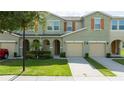 Inviting townhouse exterior with a two-car garage and well-maintained landscaping and beautiful shutters at 3181 Tocoa Cir, Kissimmee, FL 34746