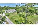 Aerial view of a white, single-story home featuring a spacious, well-maintained lawn with mature trees at 3440 La Salle Ave, St Cloud, FL 34772