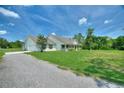 White single-story home with a covered front porch, set on a spacious lot with a long driveway at 3440 La Salle Ave, St Cloud, FL 34772