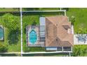 Birds eye view of a property with a pool, patio, fenced yard, and brown shingle roof at 454 Eagle Dr, Kissimmee, FL 34759