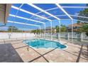 Enclosed pool area with a paver patio and a clear blue in-ground pool, with a secure screen enclosure at 454 Eagle Dr, Kissimmee, FL 34759
