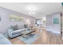 Bright living room featuring hardwood floors, neutral paint, and a view into the adjacent kitchen at 512 Maryland Ave, St Cloud, FL 34769