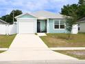 Inviting single-story home featuring a one-car garage, light blue siding, and a welcoming front porch at 5506 Glen Lake Ln, Orlando, FL 32808