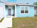 Light blue home with a welcoming front porch, gray front door, and a well-maintained lawn at 5506 Glen Lake Ln, Orlando, FL 32808