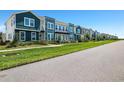 New construction townhomes boast vibrant colors, lush landscaping, and a sidewalk at 6501 Cyrils Dr, St Cloud, FL 34771