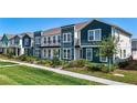 Townhomes boast colorful façades and landscaping with a well-maintained lawn at 6501 Cyrils Dr, St Cloud, FL 34771