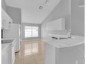 Bright kitchen featuring white cabinets, sleek countertops, and a tiled floor, bathed in natural light at 664 Eagle Pointe S, Kissimmee, FL 34746