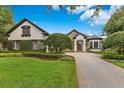 Charming home with mature trees, lush lawn, and a brick driveway at 6761 Valhalla Way, Windermere, FL 34786