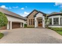 Elegant home showcasing a stone facade and paver driveway at 6761 Valhalla Way, Windermere, FL 34786