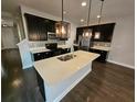 Modern kitchen features a large center island, stainless steel appliances, and stylish dark cabinetry at 7673 Ripplepointe Way, Windermere, FL 34786