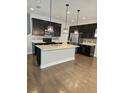 Bright kitchen with hardwood floors, center island, stainless steel appliances and mosaic tile backsplash at 7673 Ripplepointe Way, Windermere, FL 34786
